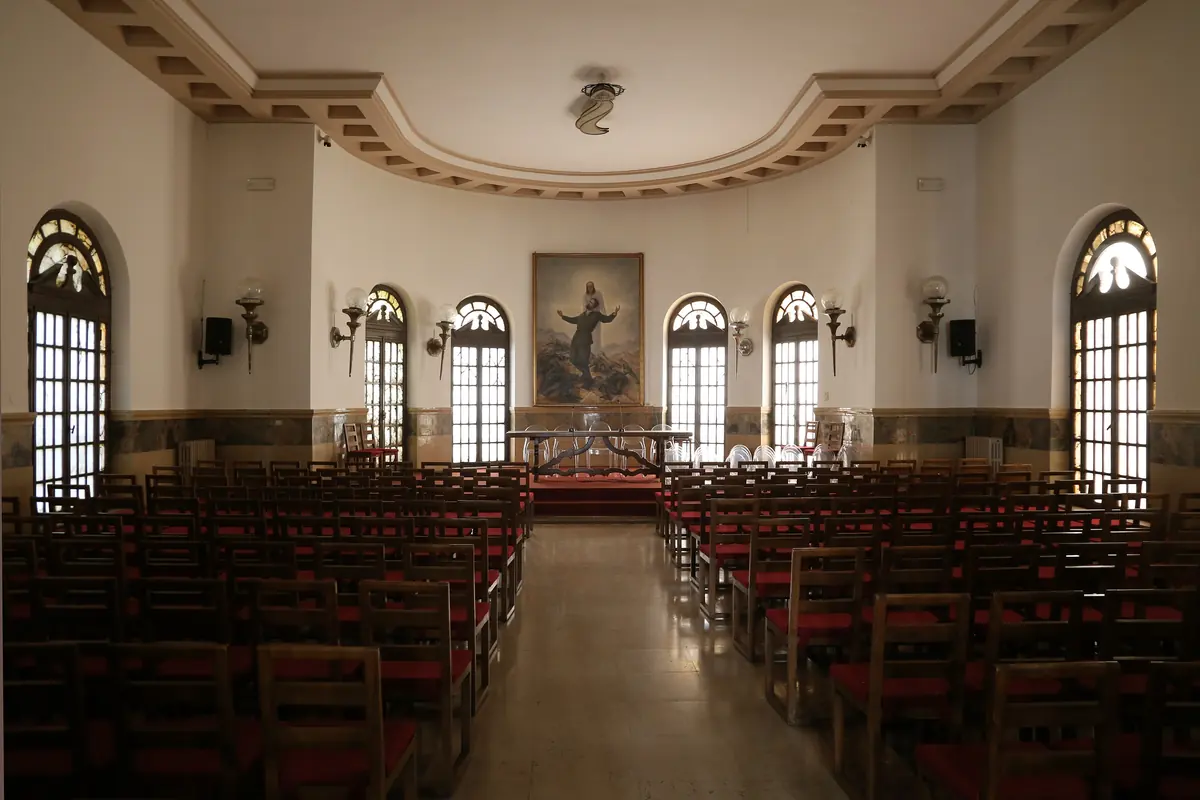 Der Sala Antonio Girelli mit Reihen hölzerner Stühle, die auf eine geschwungene Apsis mit Bogenfenstern und einem Gemälde ausgerichtet sind