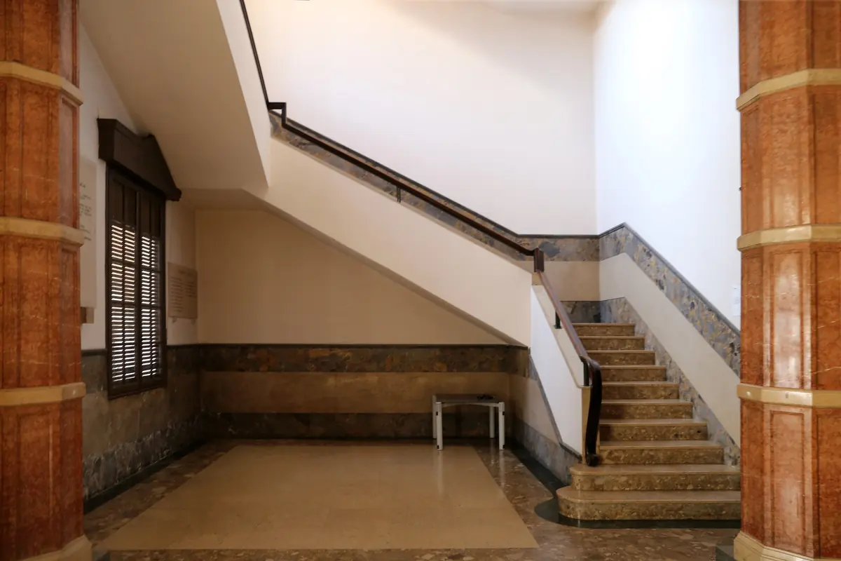 Der Treppenflur des Palastes mit einer Marmortreppe, einem schlanken Handlauf und rotbraunen Säulen